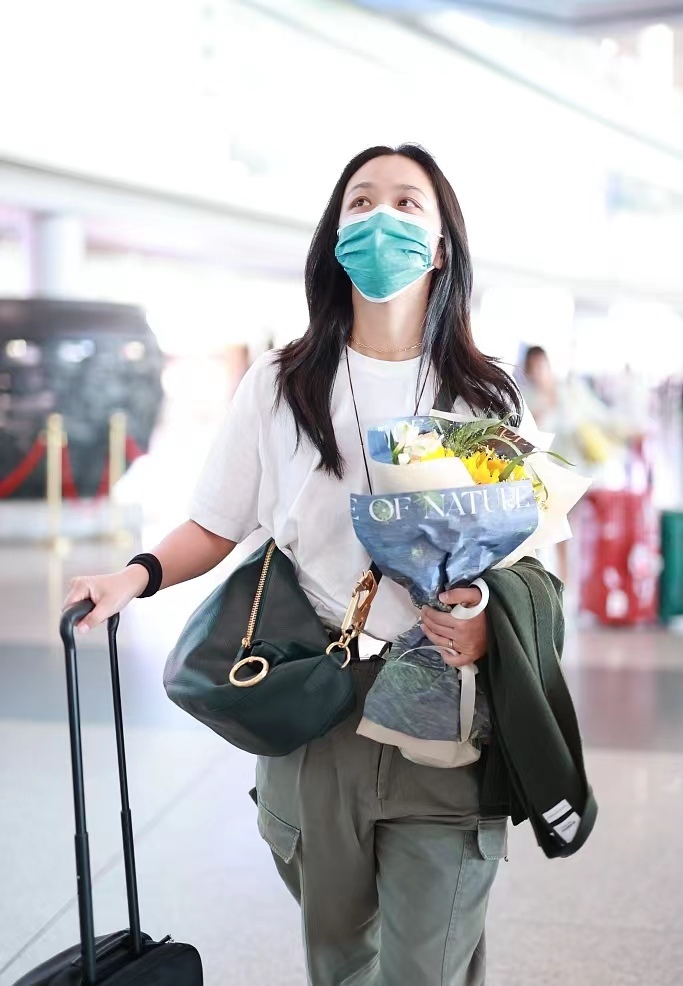 汤唯手捧鲜花现身机场 气质优雅状态好
